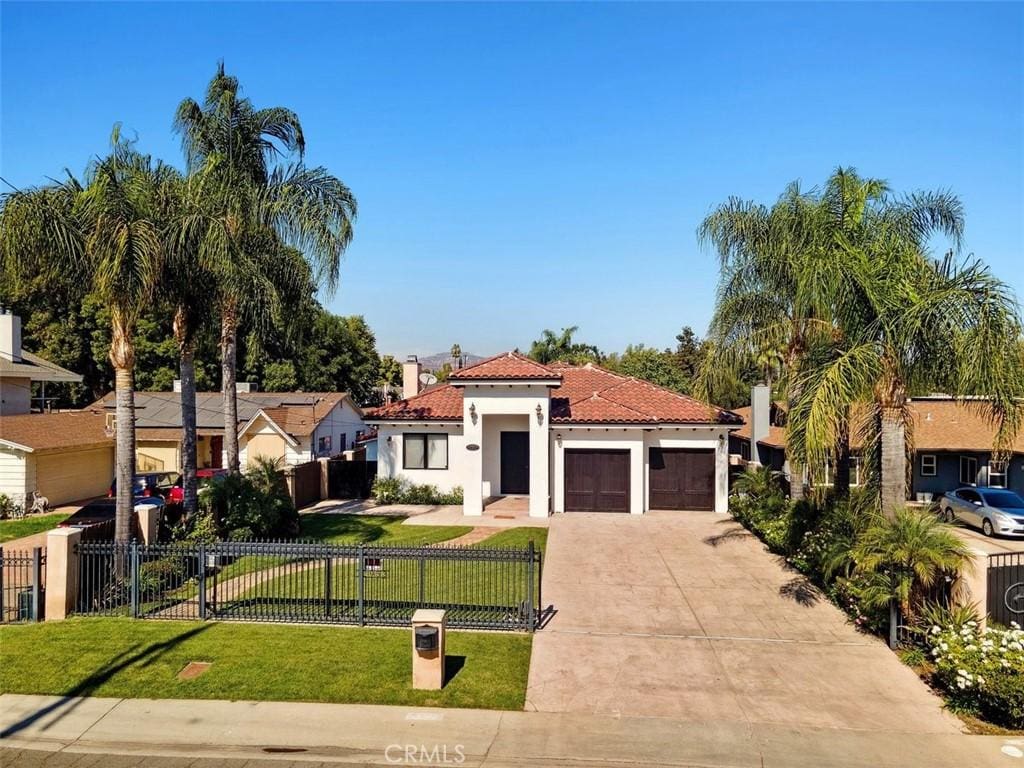 mediterranean / spanish house featuring a garage and a front yard