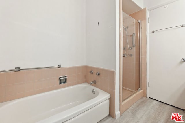 bathroom with hardwood / wood-style flooring and separate shower and tub