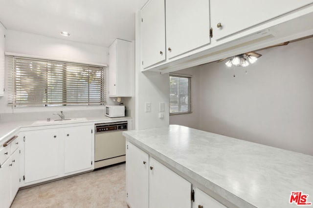 kitchen featuring white cabinetry, sink, and white appliances