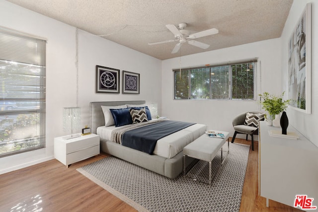 bedroom featuring a textured ceiling, hardwood / wood-style flooring, and ceiling fan