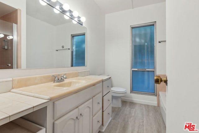 full bathroom featuring toilet, vanity, independent shower and bath, and hardwood / wood-style flooring