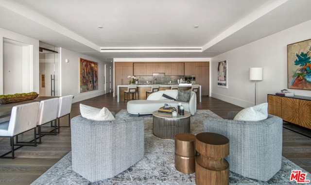 living room featuring dark hardwood / wood-style floors and a raised ceiling