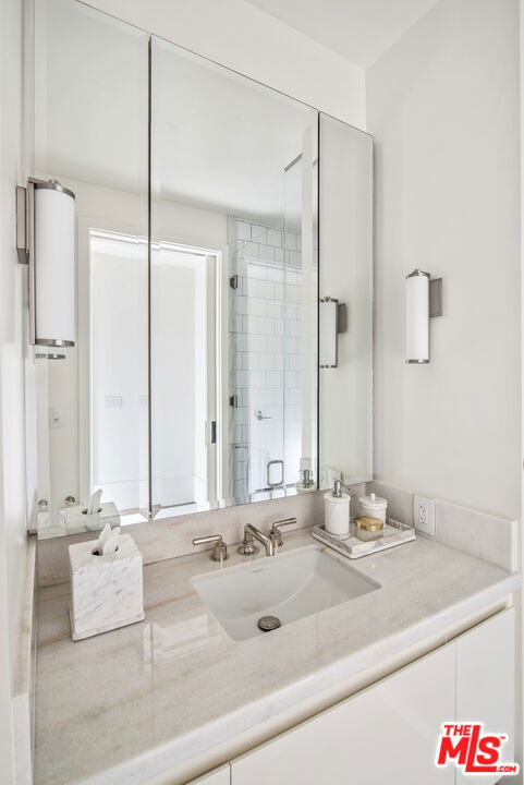 bathroom featuring walk in shower and vanity