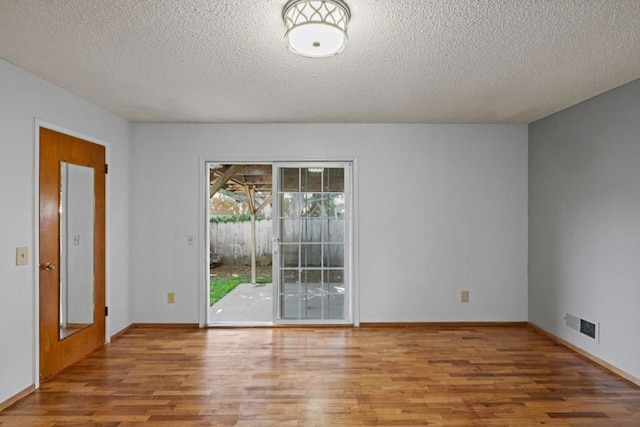 empty room featuring hardwood / wood-style floors and a textured ceiling