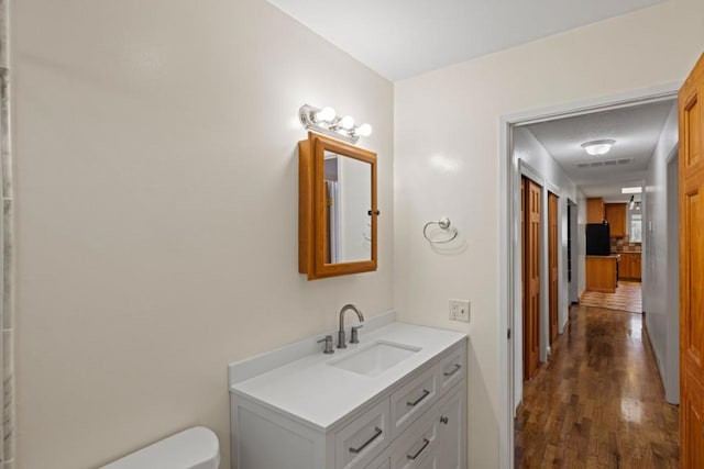 bathroom featuring vanity, toilet, and hardwood / wood-style floors