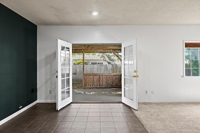 doorway with tile patterned flooring, a textured ceiling, and french doors