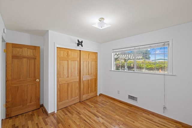 unfurnished bedroom featuring a closet and light wood-type flooring