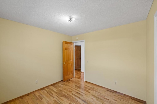 spare room featuring light hardwood / wood-style flooring and a textured ceiling