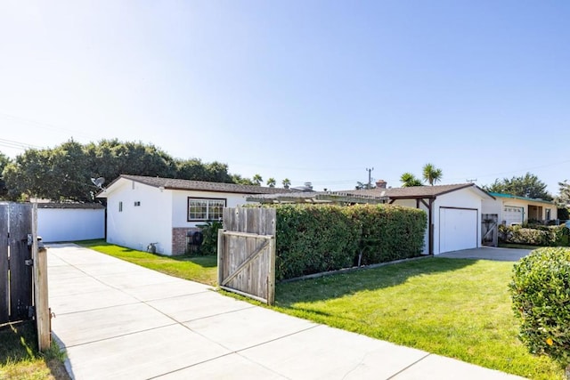 single story home with a garage, an outbuilding, and a front yard