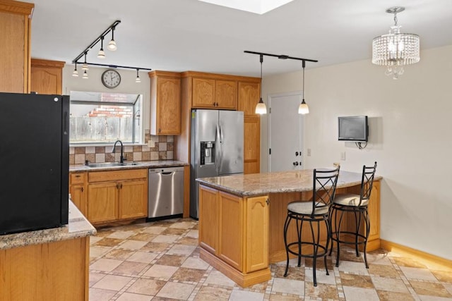 kitchen featuring sink, decorative light fixtures, stainless steel appliances, and backsplash