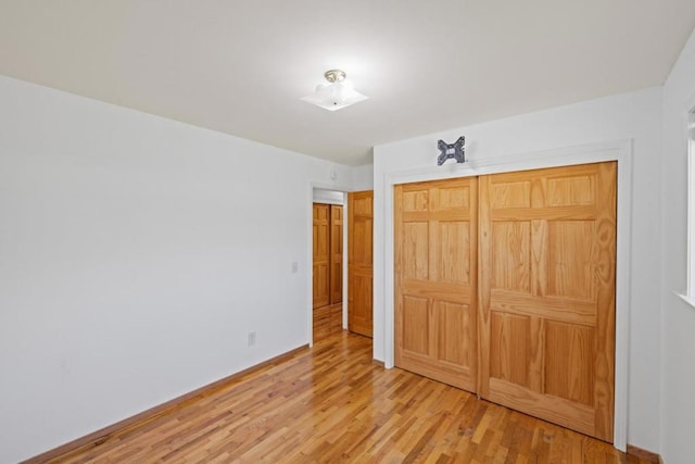 unfurnished bedroom featuring light hardwood / wood-style floors and a closet