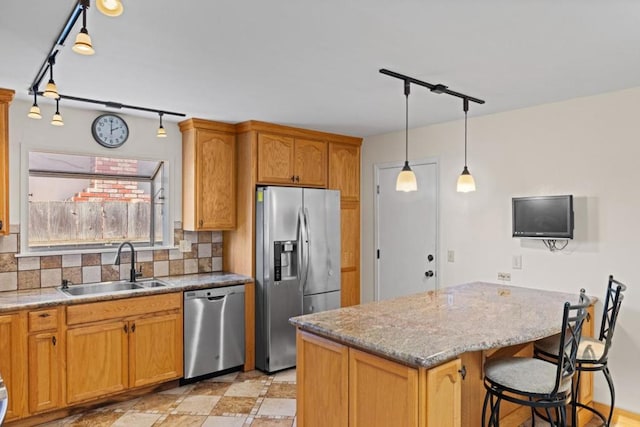 kitchen featuring a breakfast bar, sink, backsplash, a center island, and stainless steel appliances