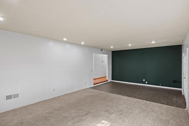 unfurnished room with dark carpet