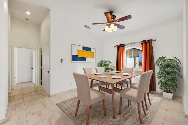 tiled dining space with ceiling fan and lofted ceiling