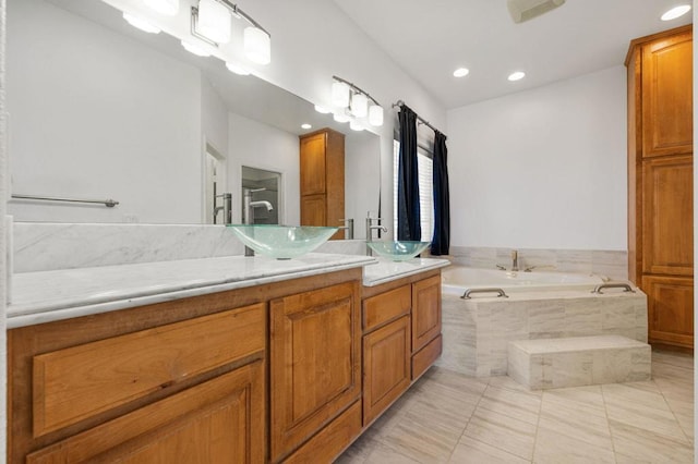 bathroom with vanity, tile patterned floors, and tiled tub