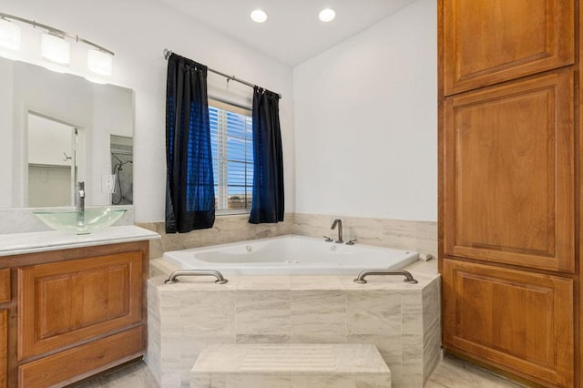 bathroom featuring tile patterned flooring, vanity, and a relaxing tiled tub