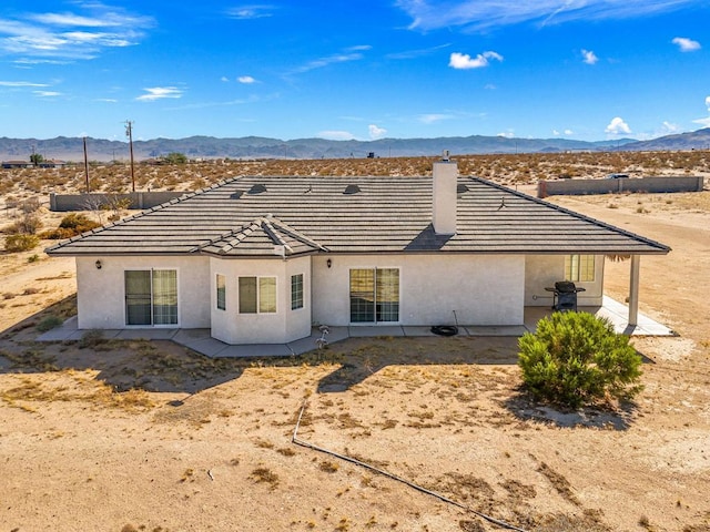 back of house featuring a mountain view and a patio