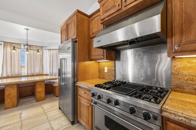 kitchen with tasteful backsplash, extractor fan, high end appliances, pendant lighting, and light tile patterned floors