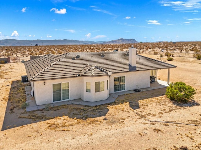 back of house featuring a mountain view and a patio