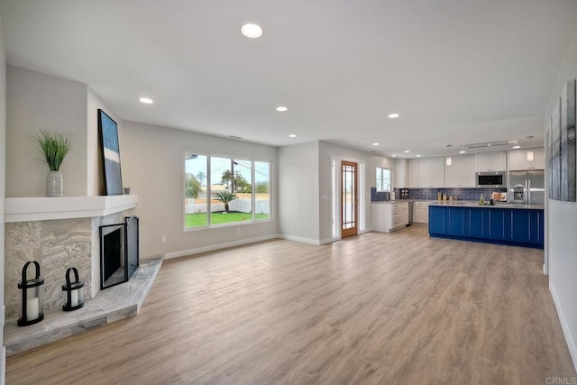 unfurnished living room featuring light hardwood / wood-style flooring and sink