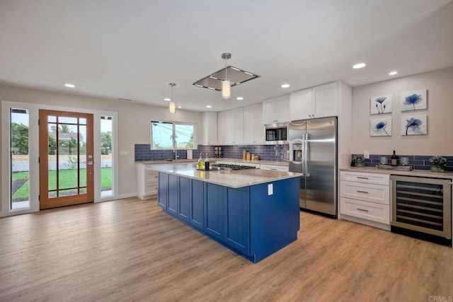 kitchen with a kitchen island, pendant lighting, white cabinetry, appliances with stainless steel finishes, and wine cooler