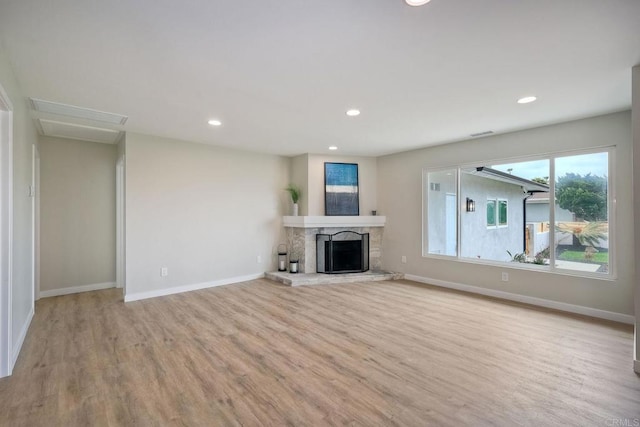 unfurnished living room featuring light wood-type flooring and a fireplace