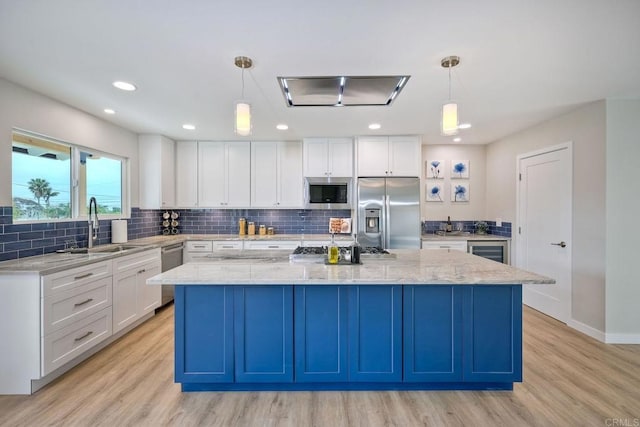 kitchen with appliances with stainless steel finishes, pendant lighting, and a center island