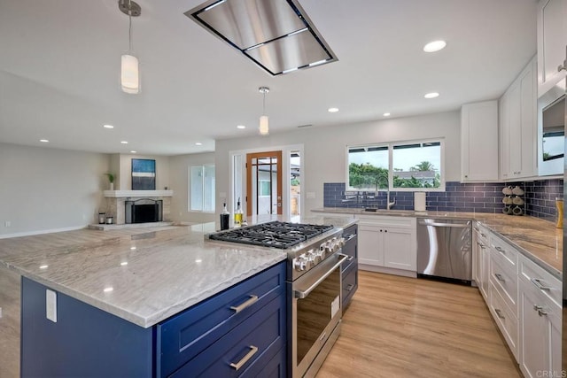 kitchen featuring white cabinets, stainless steel appliances, and decorative light fixtures