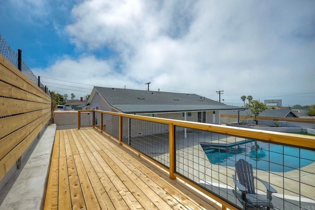 wooden deck with a fenced in pool