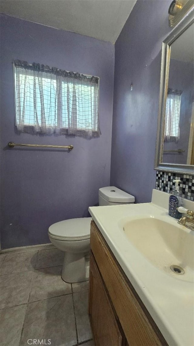 bathroom with toilet, tile patterned floors, backsplash, and vanity