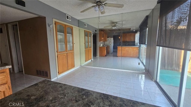 unfurnished sunroom with ceiling fan