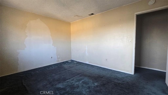 carpeted empty room with a textured ceiling