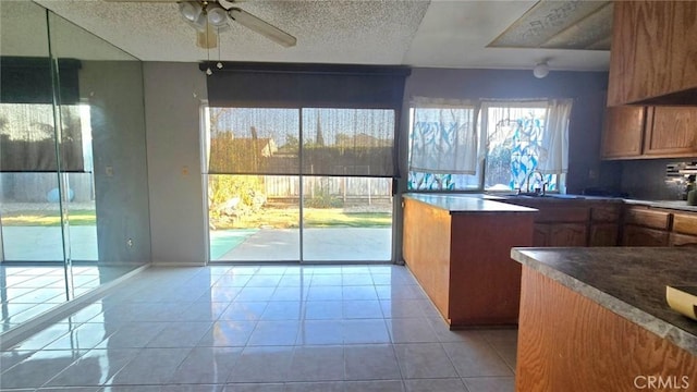 kitchen featuring ceiling fan, sink, and light tile patterned flooring