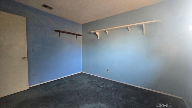 carpeted spare room featuring a textured ceiling