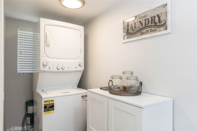 washroom with cabinets and stacked washer and dryer