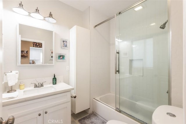 full bathroom featuring shower / bath combination with glass door, vanity, and toilet