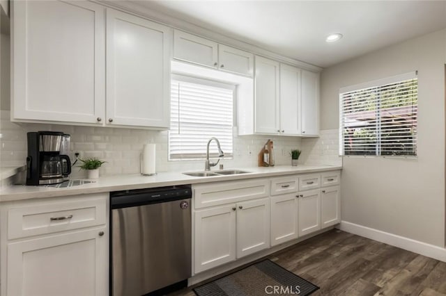 kitchen with stainless steel dishwasher, sink, and white cabinetry