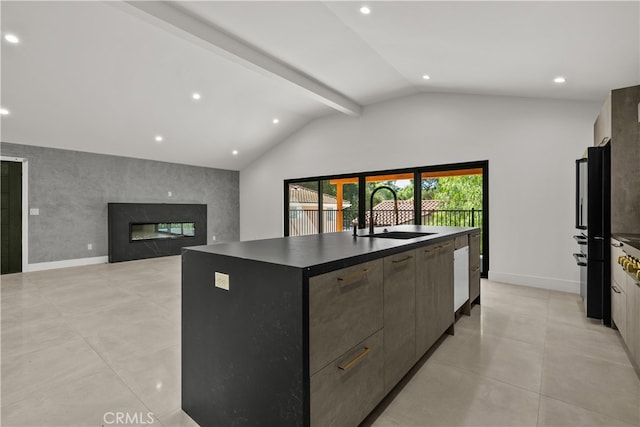 kitchen featuring lofted ceiling with beams, black fridge, a center island with sink, sink, and a fireplace