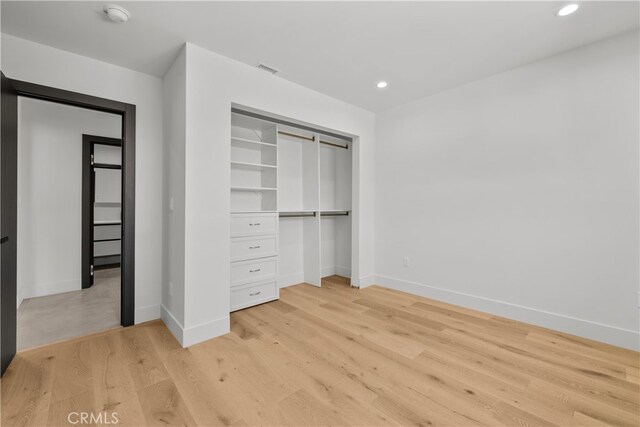 unfurnished bedroom featuring light wood-type flooring and built in desk