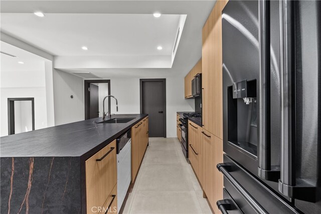 kitchen featuring appliances with stainless steel finishes, a kitchen island with sink, and sink