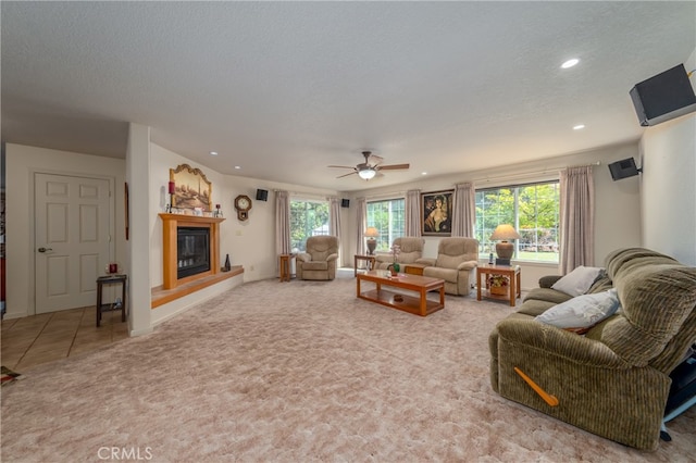 carpeted living room with ceiling fan and a textured ceiling