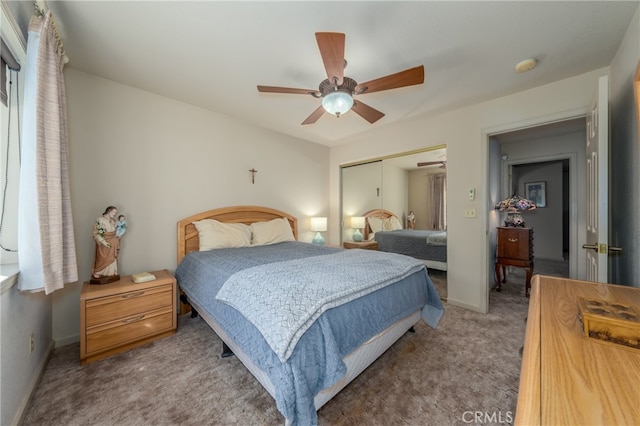 carpeted bedroom with ceiling fan and a closet