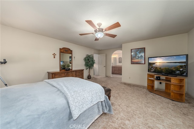 bedroom with ensuite bathroom, ceiling fan, and carpet flooring