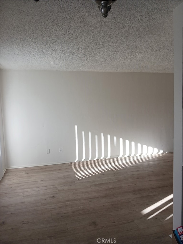 spare room featuring hardwood / wood-style floors and a textured ceiling