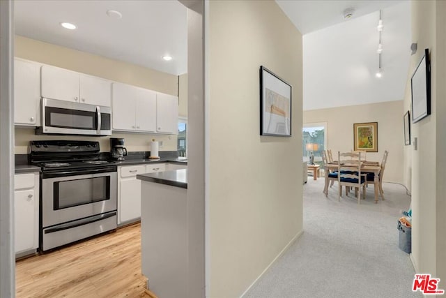 kitchen with white cabinetry, light colored carpet, appliances with stainless steel finishes, and rail lighting