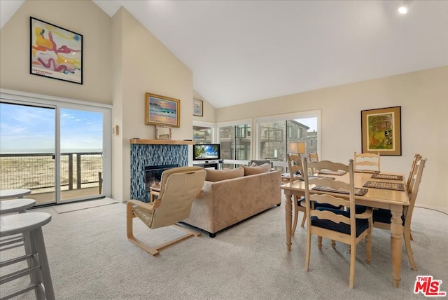 carpeted living room with high vaulted ceiling and a tile fireplace