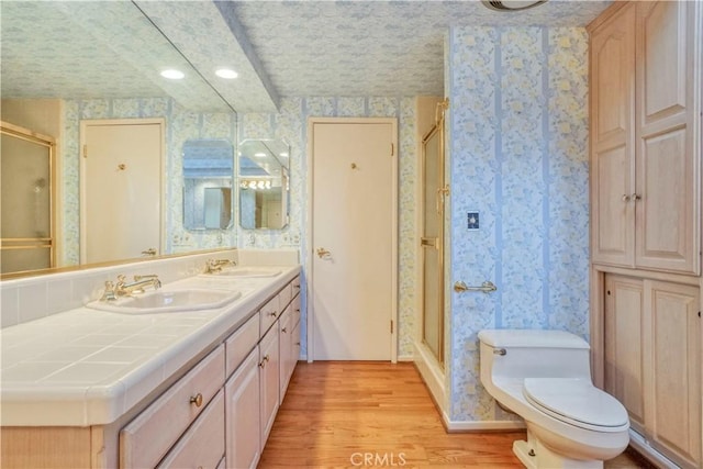 bathroom featuring wood-type flooring, vanity, toilet, and walk in shower