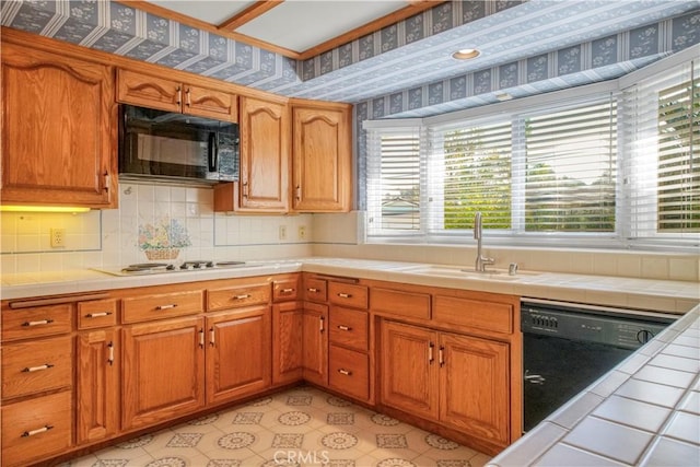 kitchen featuring black appliances, decorative backsplash, sink, and tile countertops