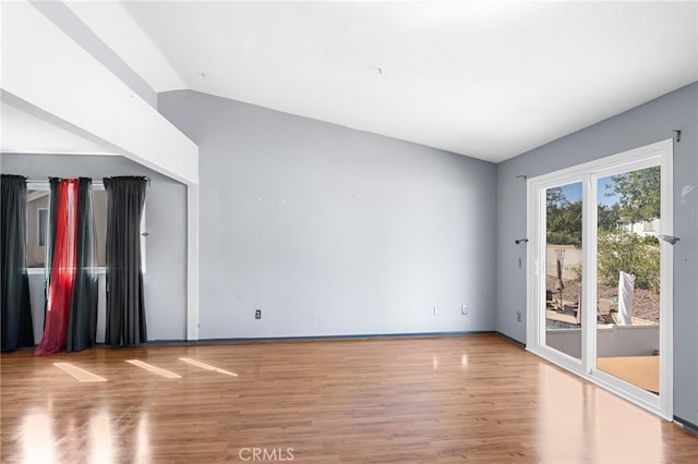 unfurnished living room featuring lofted ceiling and wood-type flooring