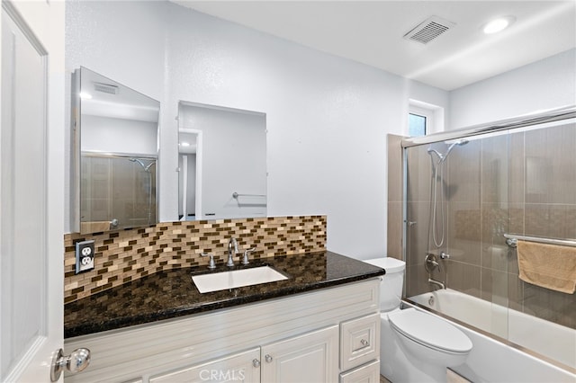 full bathroom featuring shower / bath combination with glass door, vanity, toilet, and tasteful backsplash